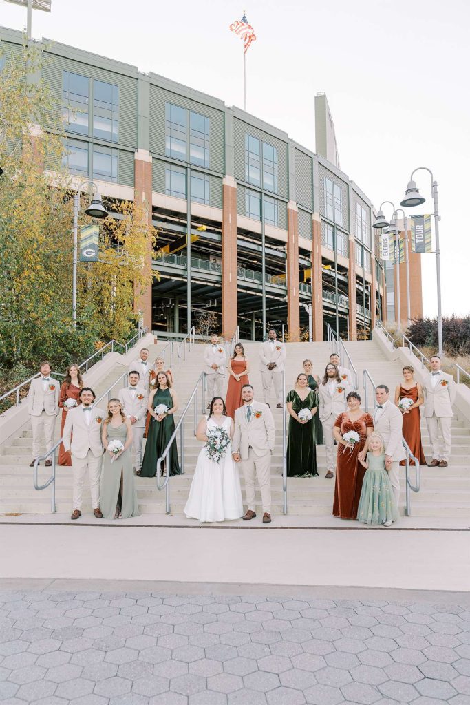 Wedding party poses outside of Lambeau Field in Green Bay, WI