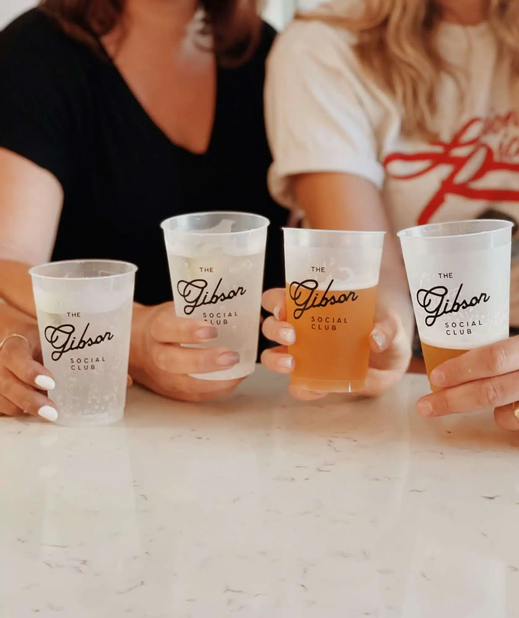 Glasses of beer with Gibson Social Club logo on it.