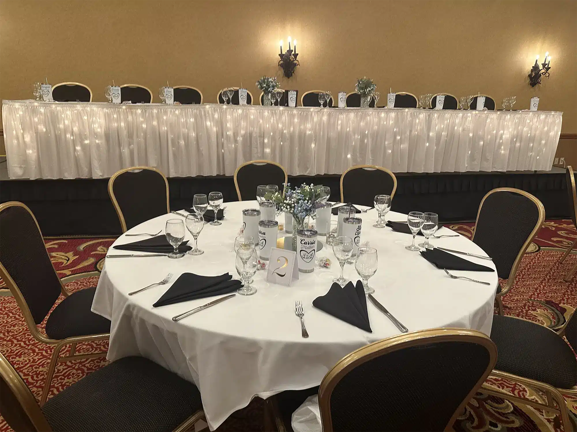 Head table in white with black napkins at Tundra Lodge wedding.