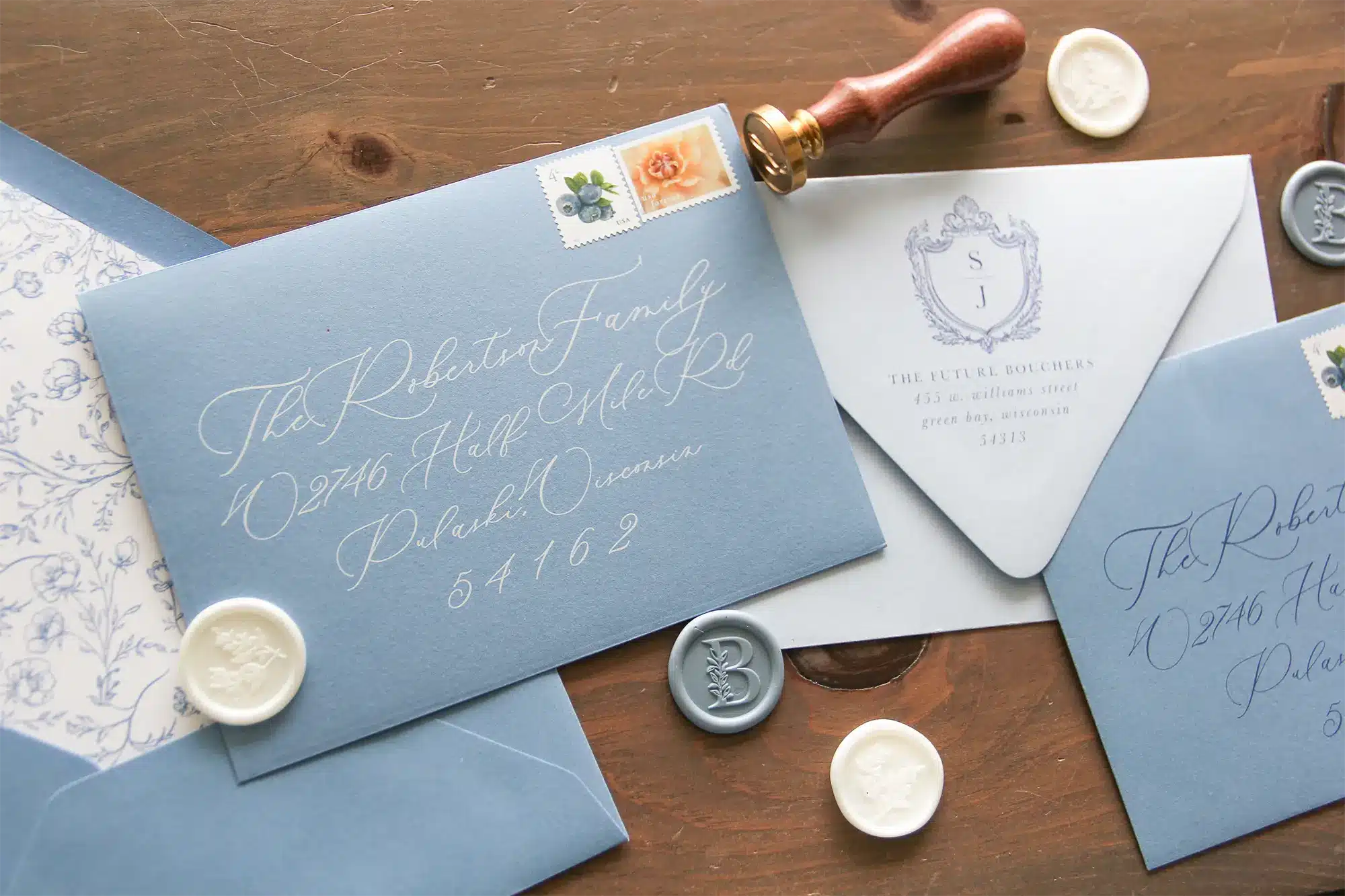 Victorian style invitations in dusty blue with floral lined envelopes and wax monogram seals