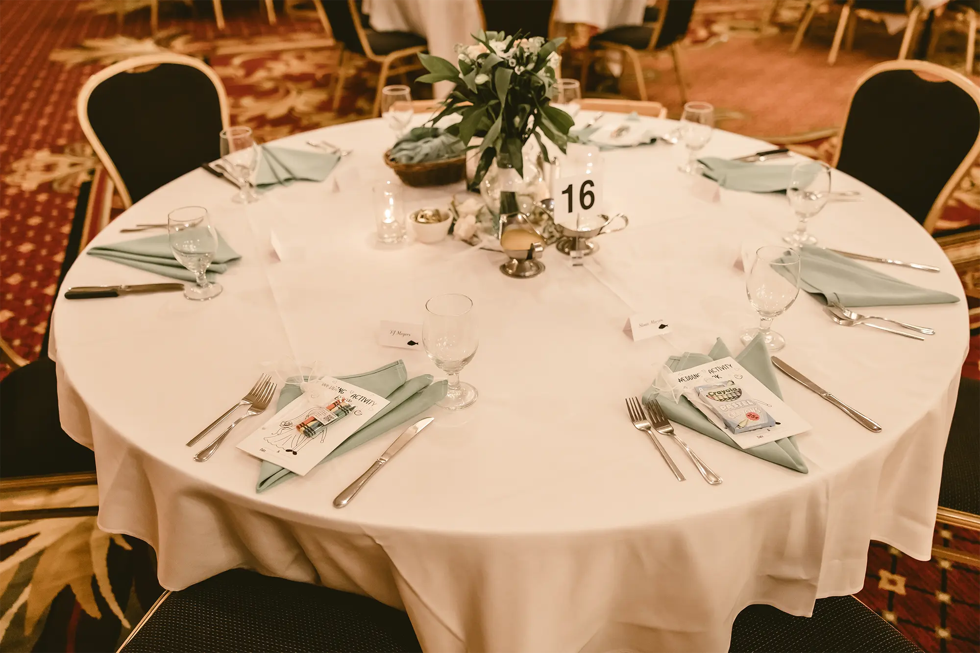 Table 16 with wedding activity books for child guests at Tundra Lodge reception.