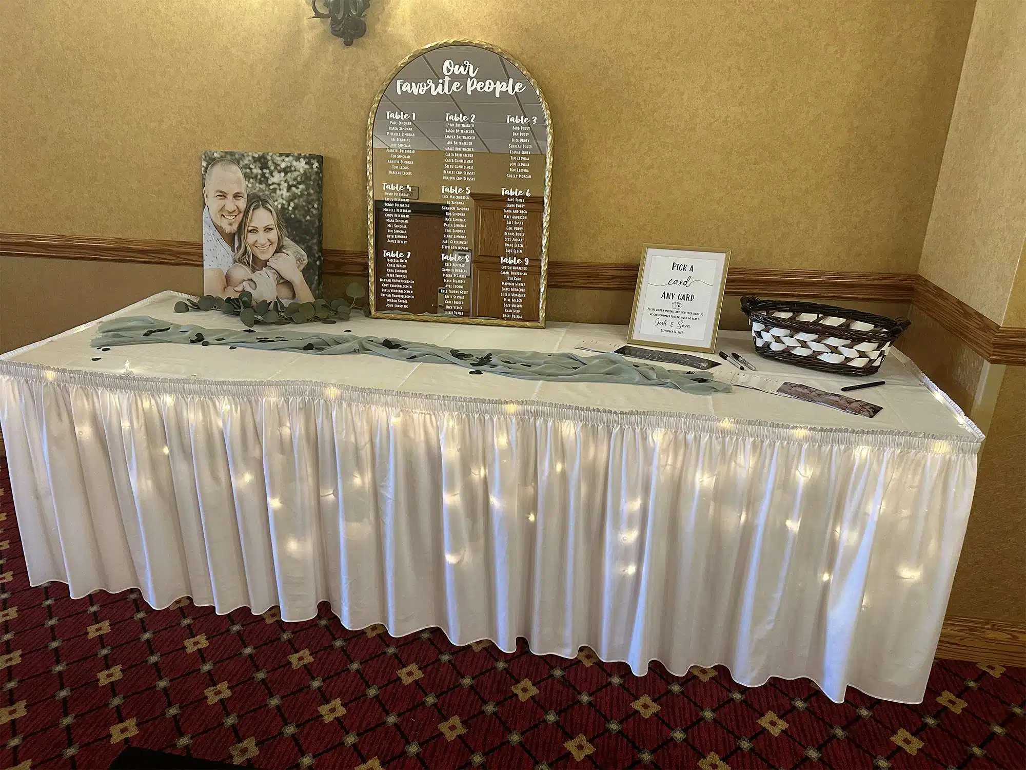 Wedding seating chart display with welcome table, signage, and greenery at Tundra Lodge Resort & Conference Center