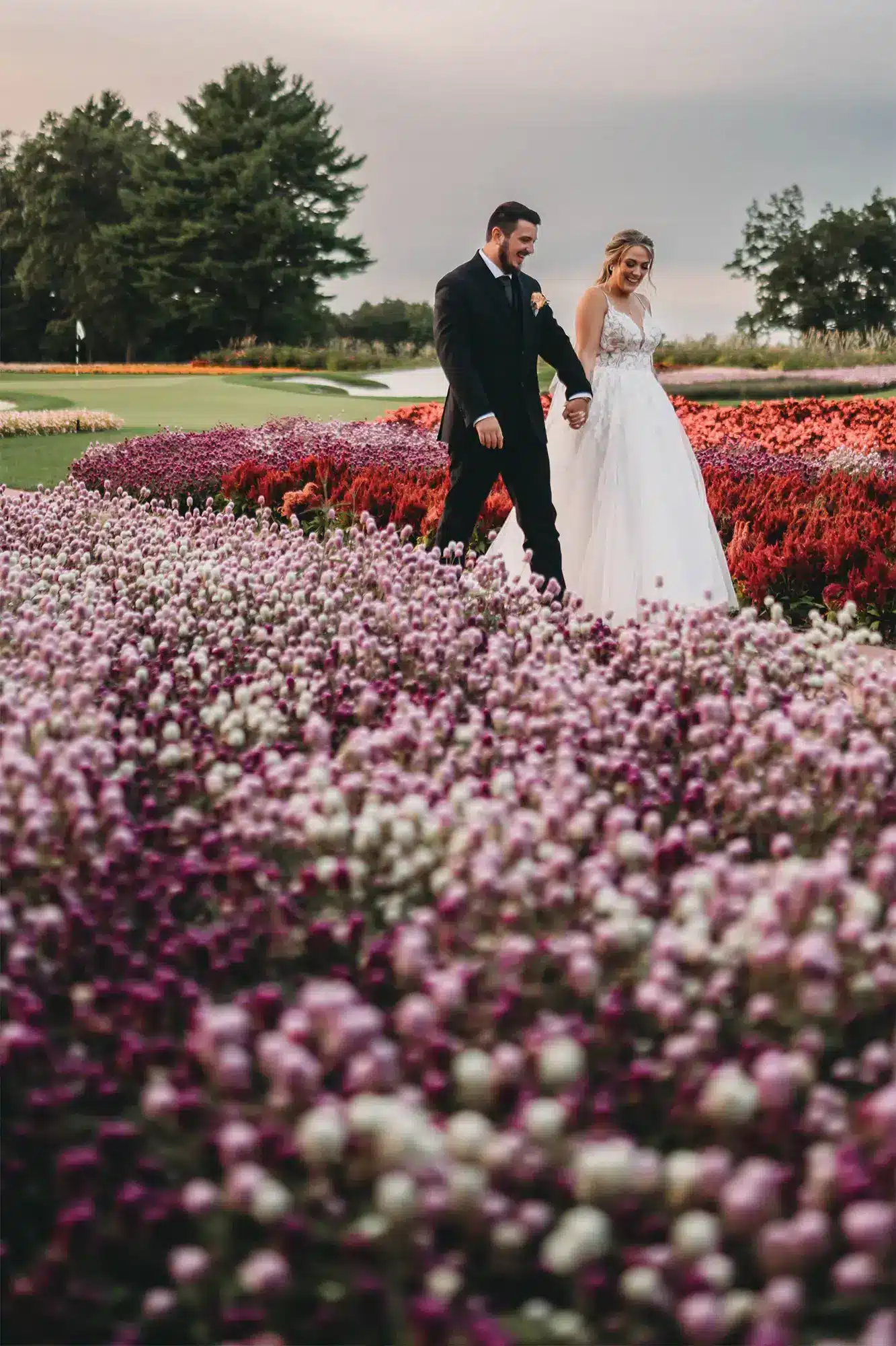 elegant-stevens.-point-wedding-70 Bride and groom walk hand in hand through the lush blooms at Sentry World in Stevens Point, WI.