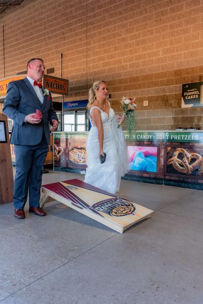 Bride and Groom play corn hole game at their wedding reception