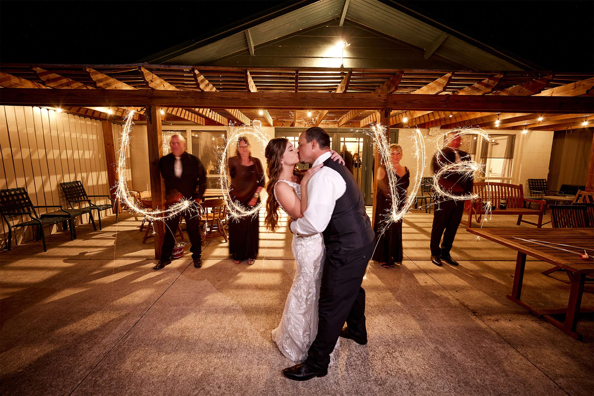 Love written in sparklers with Bride and Groom