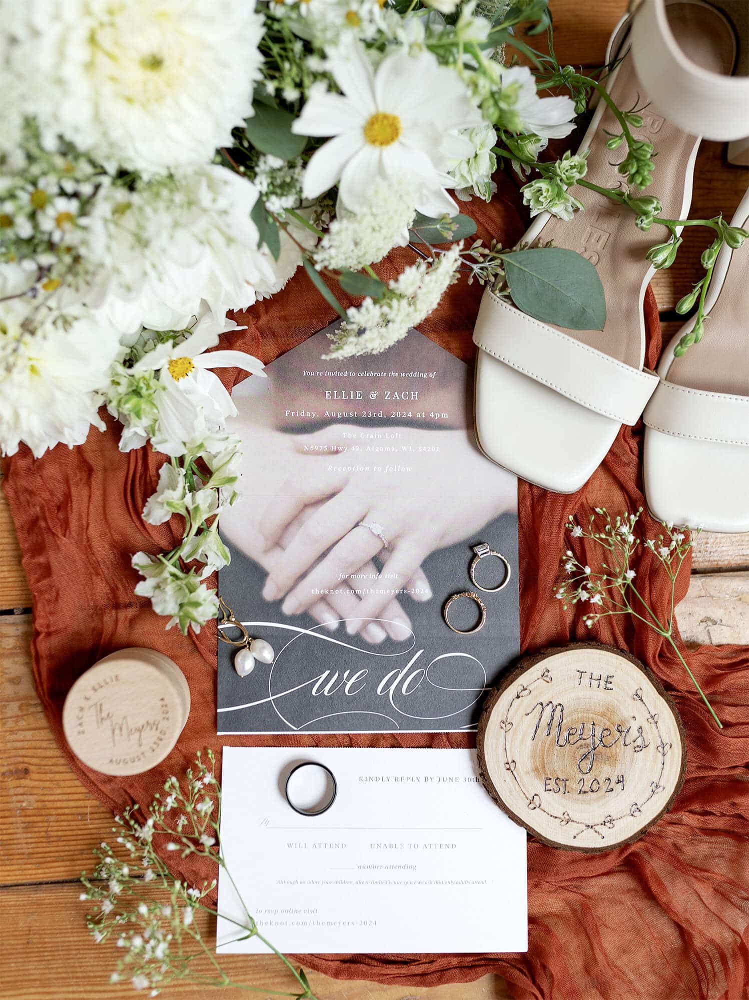 Wedding flat lay with invitations, shoes, and flowers
