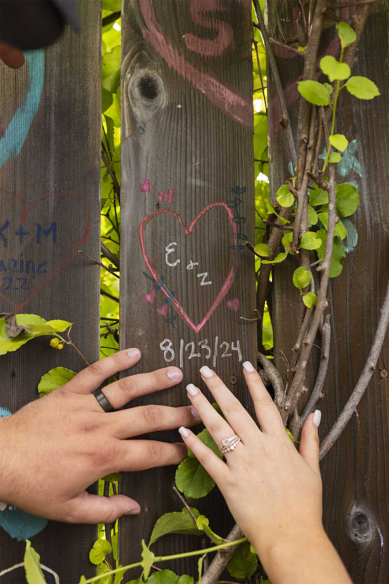 Bride and groom engrave their initials into a deck board