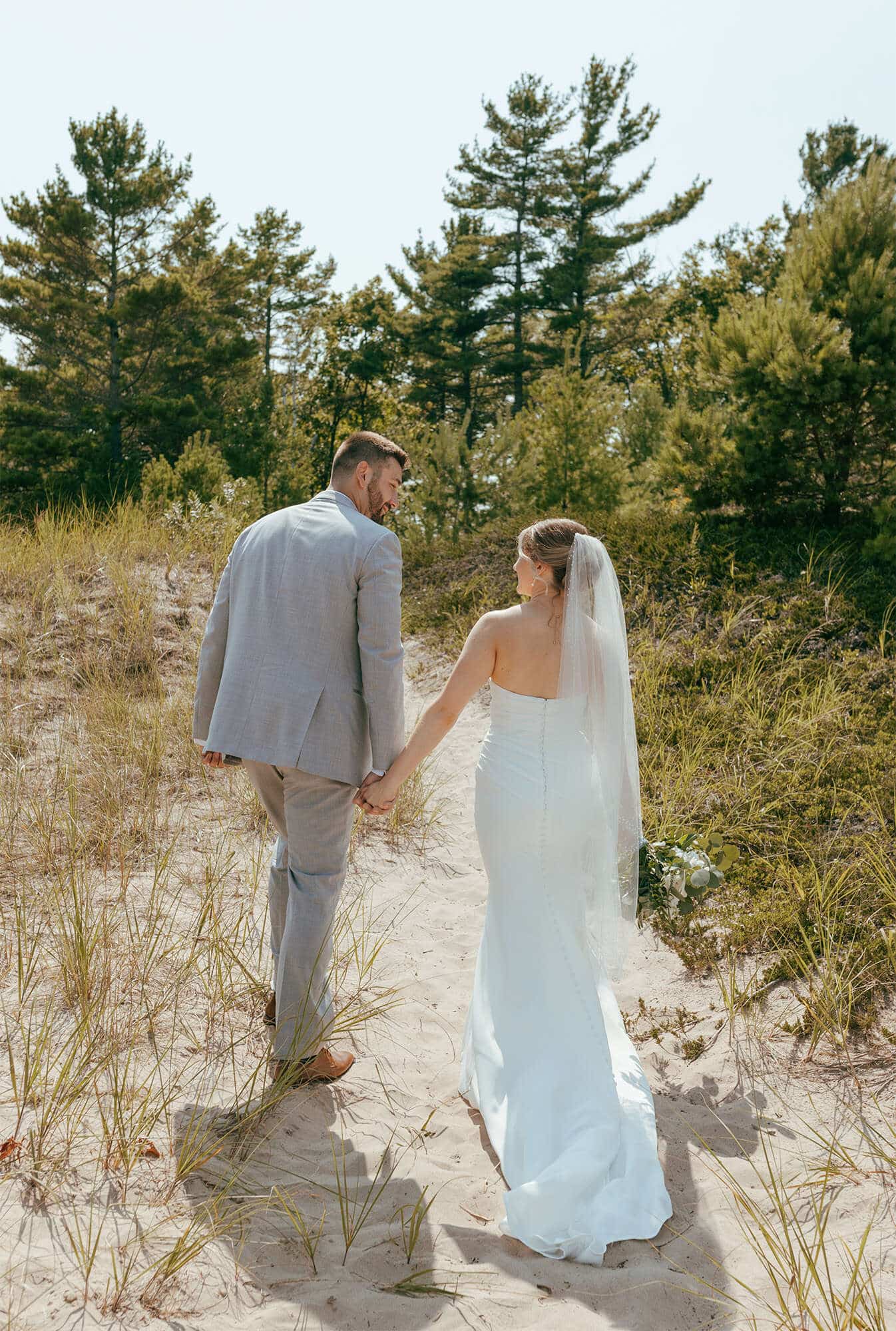 Bride and groom walking along Point Beach State Park in Two Rivers