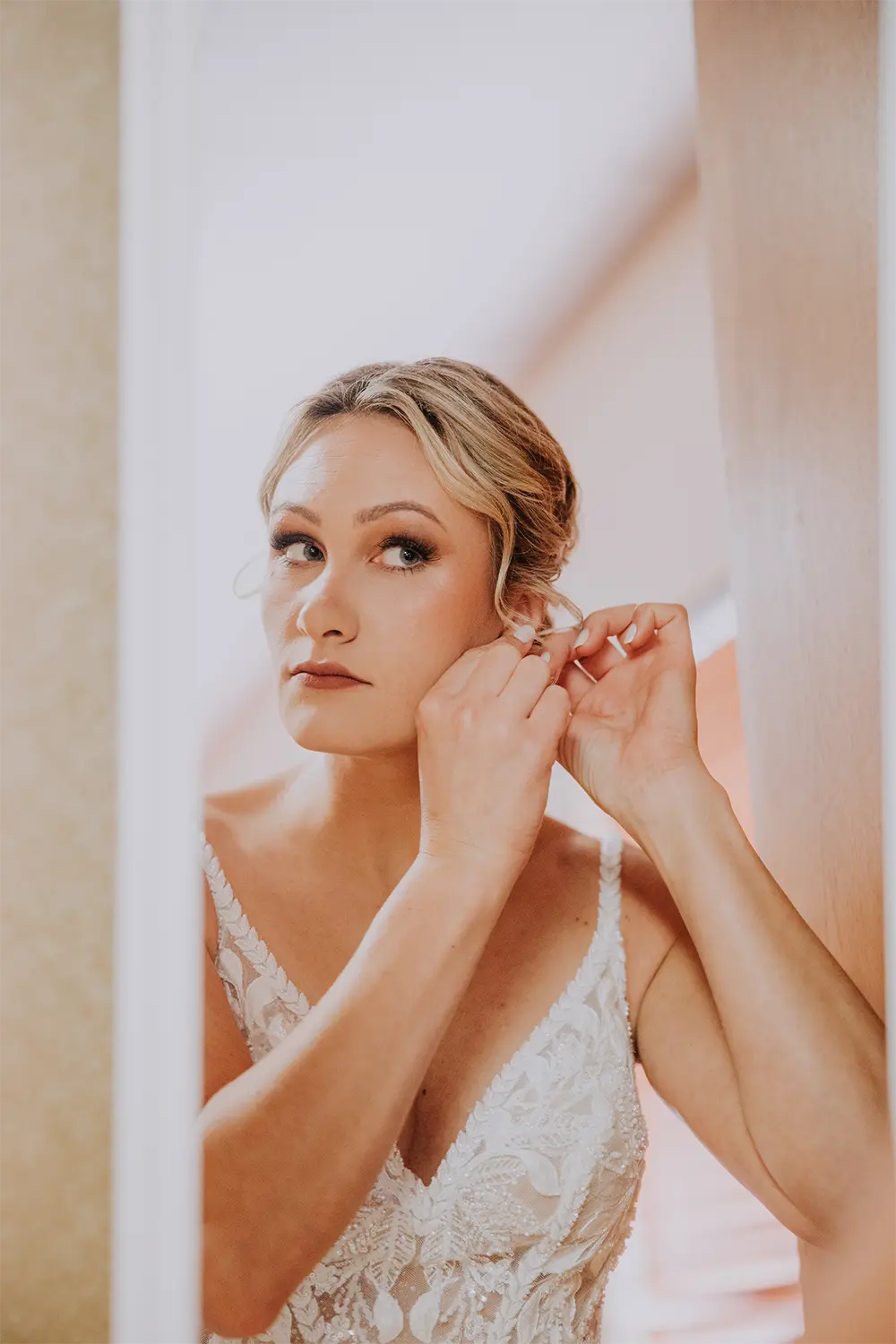 beautiful-bride-placing-earring Bride places earring before her Tundra Lodge wedding.