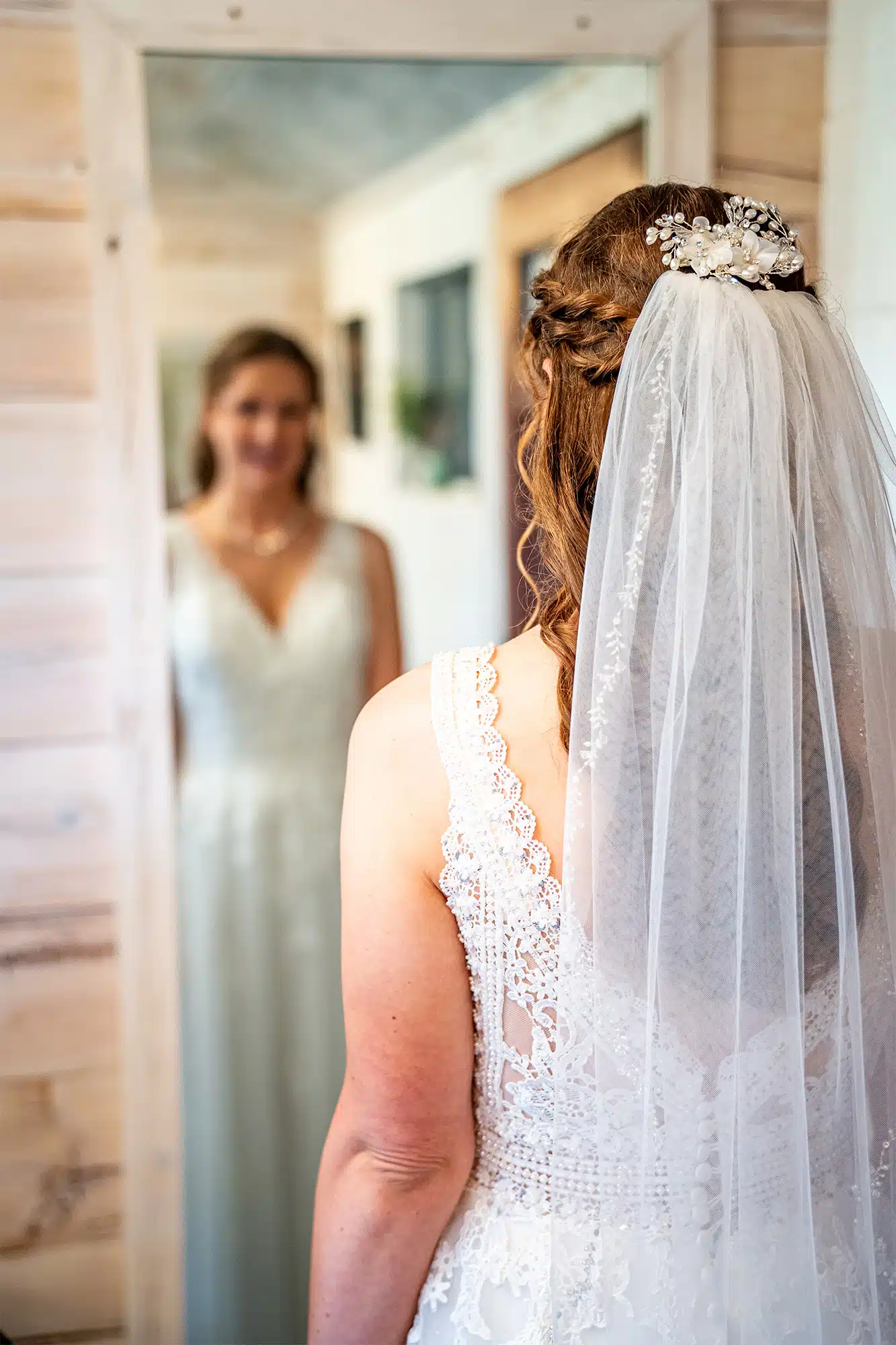 Bridal reflections- Sam Lauersdorf Photography Bride in veil gazes at her reflection in mirror at Woelfel Homestead Farm Venue.