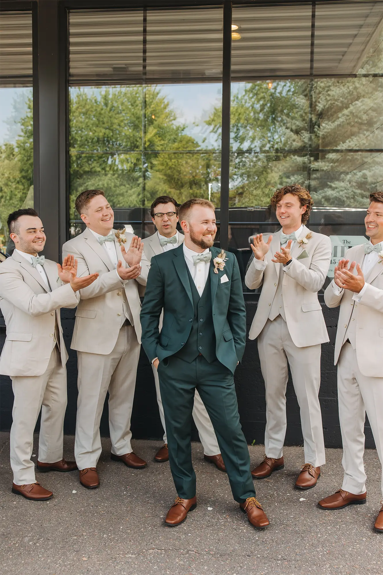 Groom pose with groomsmen at the Mill Events in Chetek. Groom in green suit poses with groomsmen.