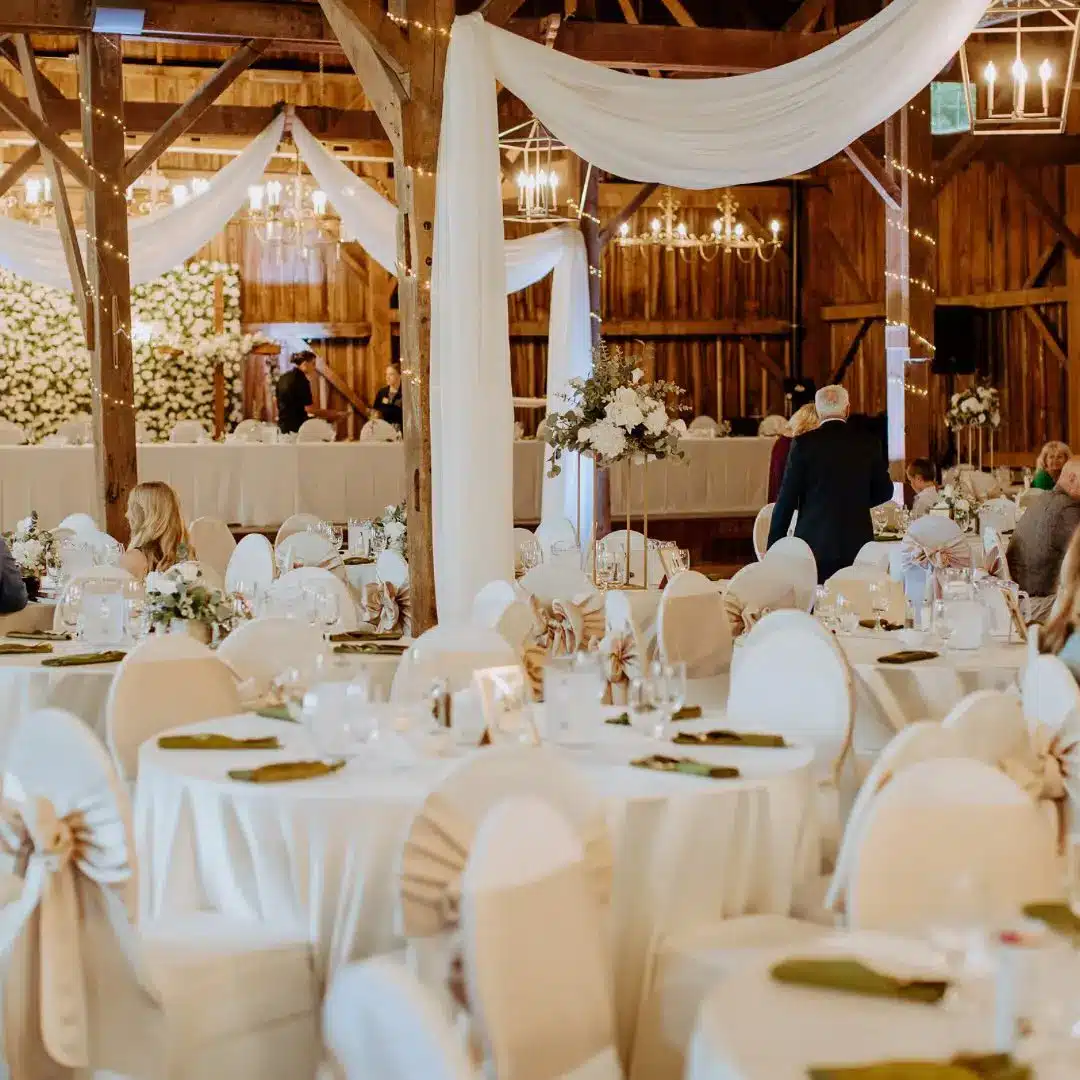 white chiffon draping amongst linen covered chairs and tables by I Do Decorating & Rental Service