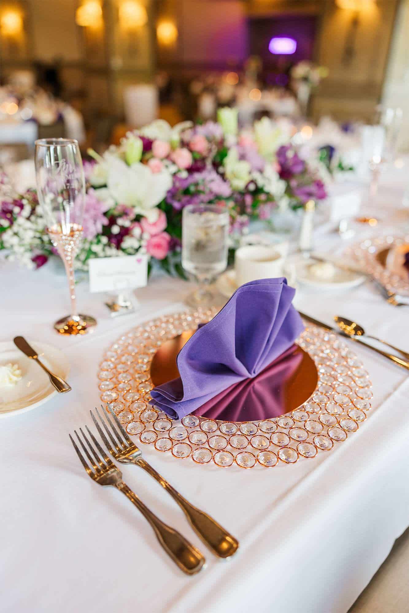 Elegant gold charger with purple napkin at SentryWorld wedding reception