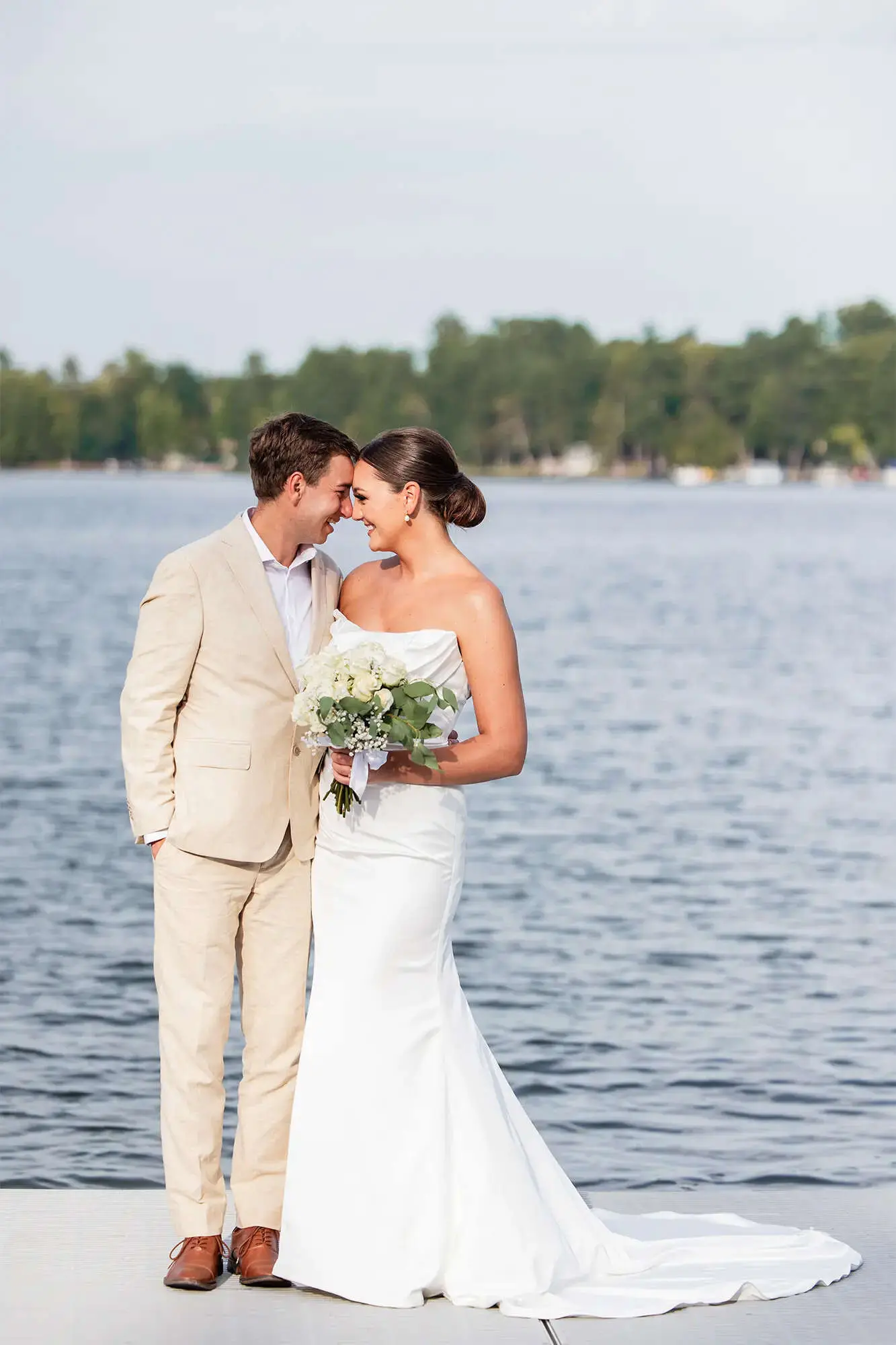 Clintonville-lakeside-wedding-reception-13 Couple standing on pier with opposite shoreline in distance