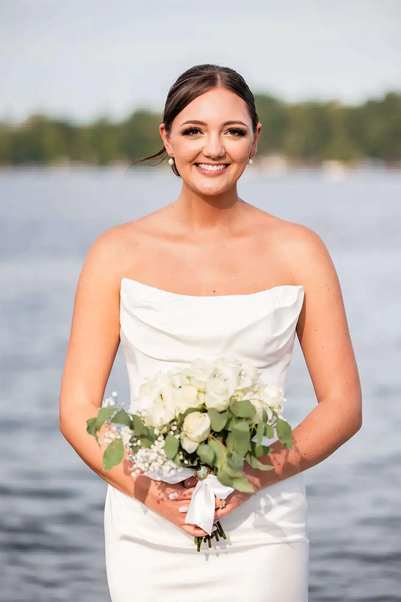 Clintonville-lakeside-wedding-reception-15 Bride in chiffon strapless fitted gown holding ivory rose floral bouquet
