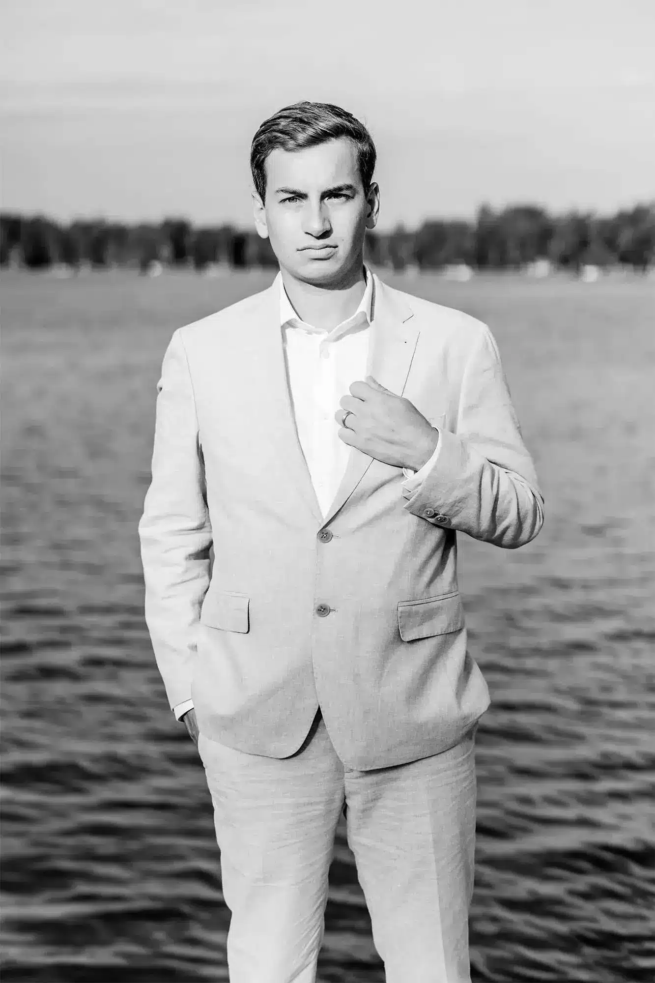 Clintonville-lakeside-wedding-reception-26 Groom standing on pier with hand on lapel