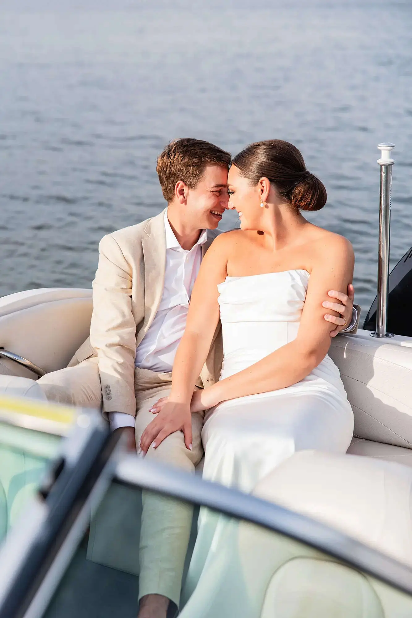 Clintonville-lakeside-wedding-reception-27 Bride and groom sitting on boat with heads together