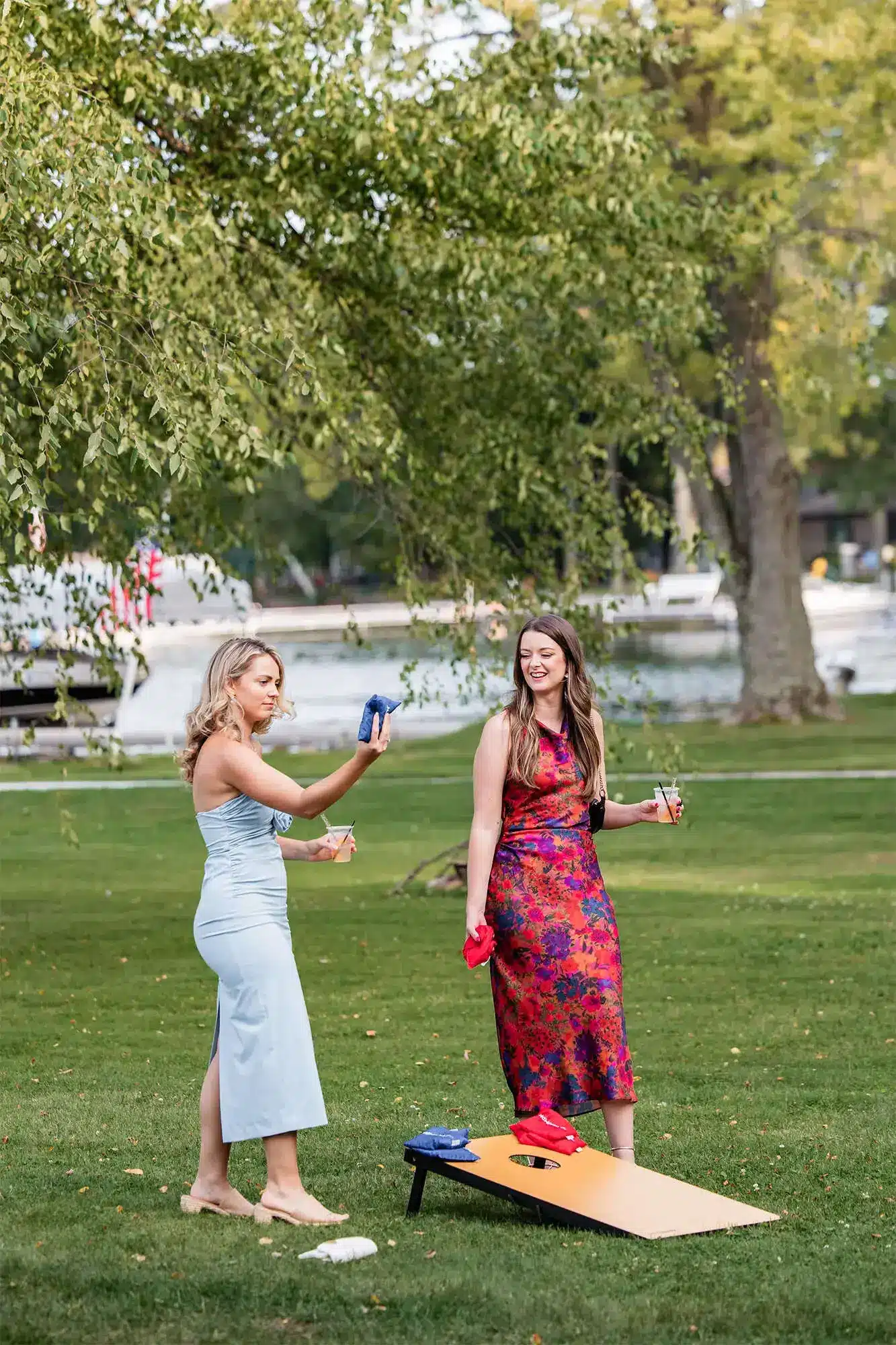 Clintonville-lakeside-wedding-reception-43 Women guests playing bags game with lake in background