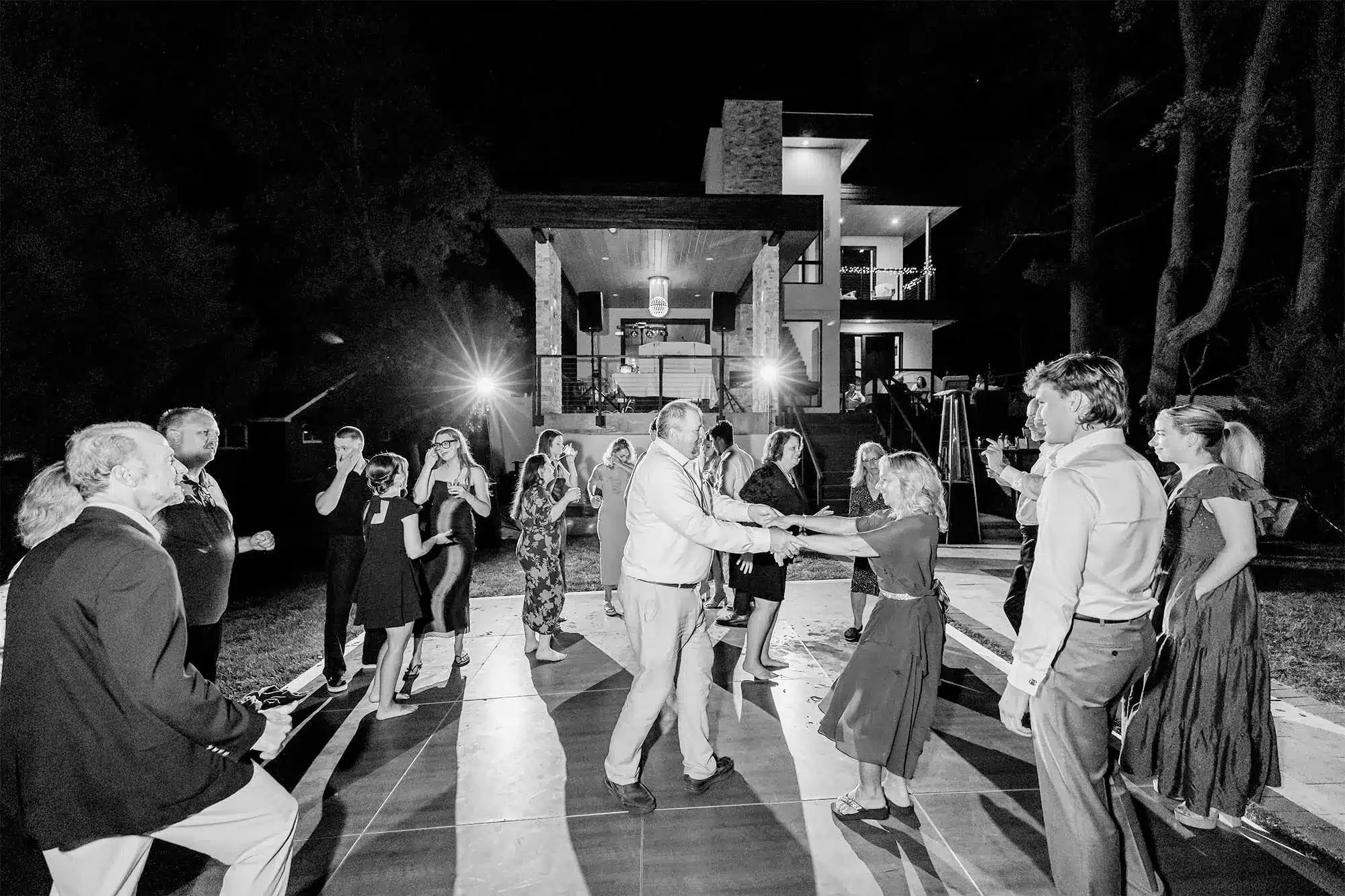 clintonville-lakeside-wedding-reception-84 Guest dancing to music by Record Entertainment with bride's family home lit up in background