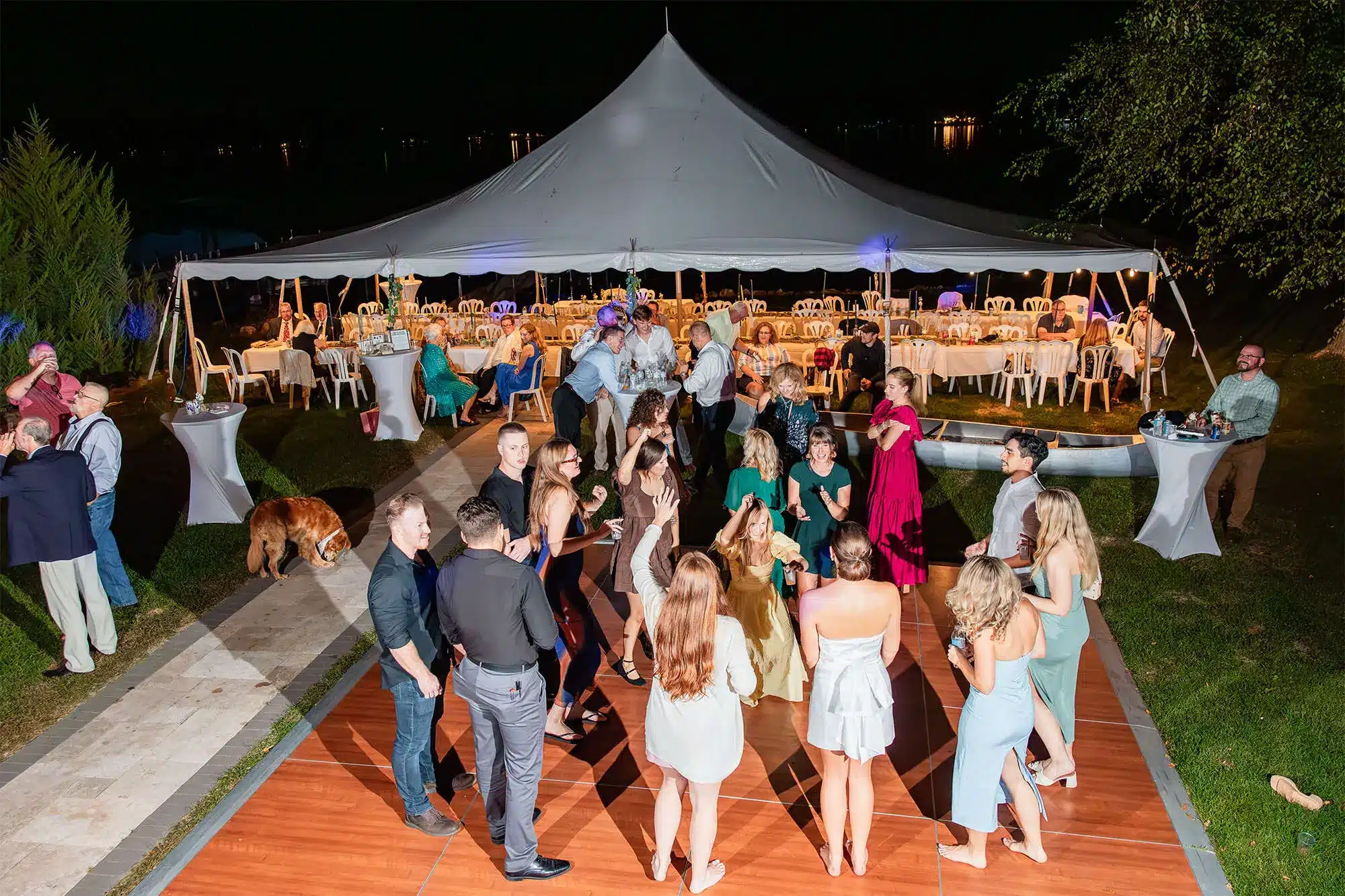 clintonville-lakeside-wedding-reception-87 Guest on wood dance floor in the evening outside lit up white tent