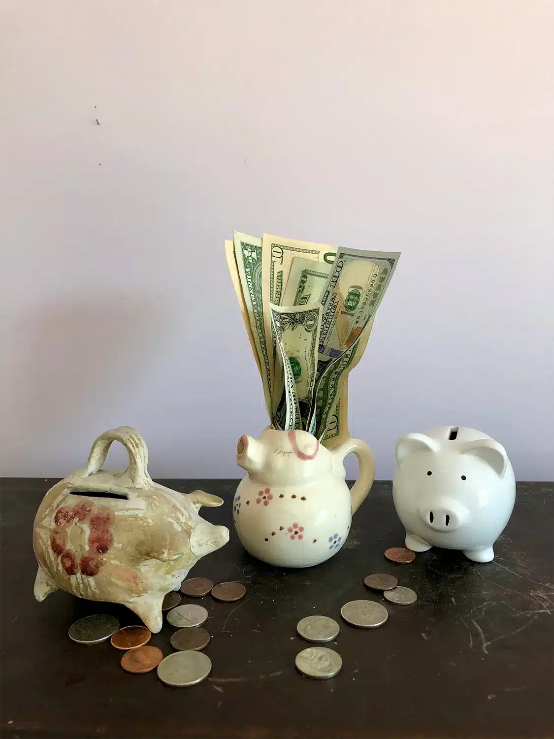 Antique porcelain piggy banks on table with money. Antique porcelain piggy banks on table with money.