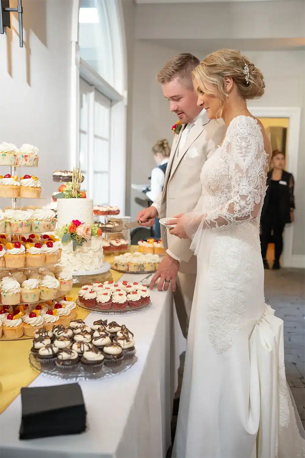 Kylie and Trevor begin to cut their wedding cake at fall Heidel House wedding. Kylie and Trevor begin to cut their wedding cake at fall Heidel House wedding.