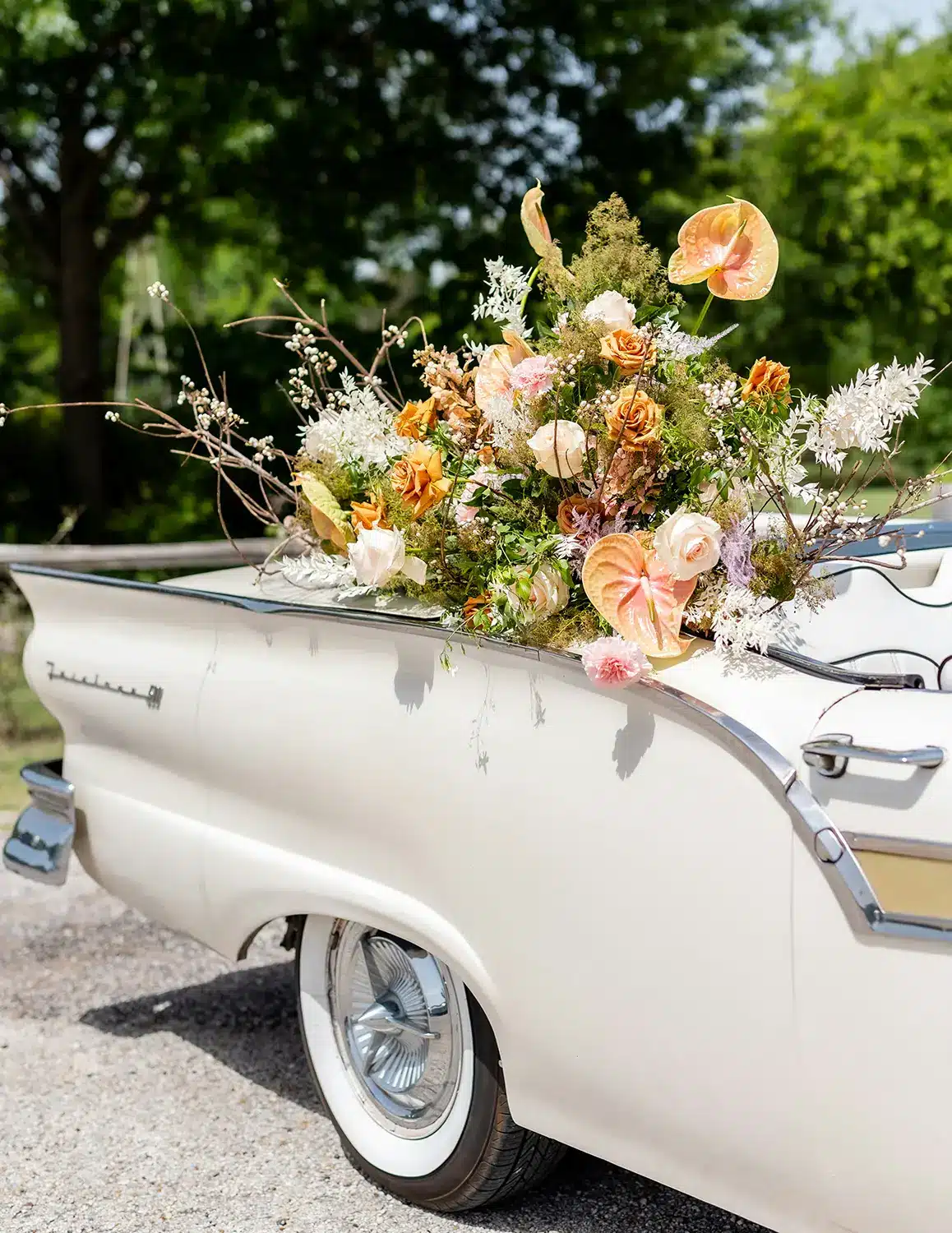 monika-normand-_CndUAkS_MQ-unsplash copy garden themed spring florals hanging out of vintage white car