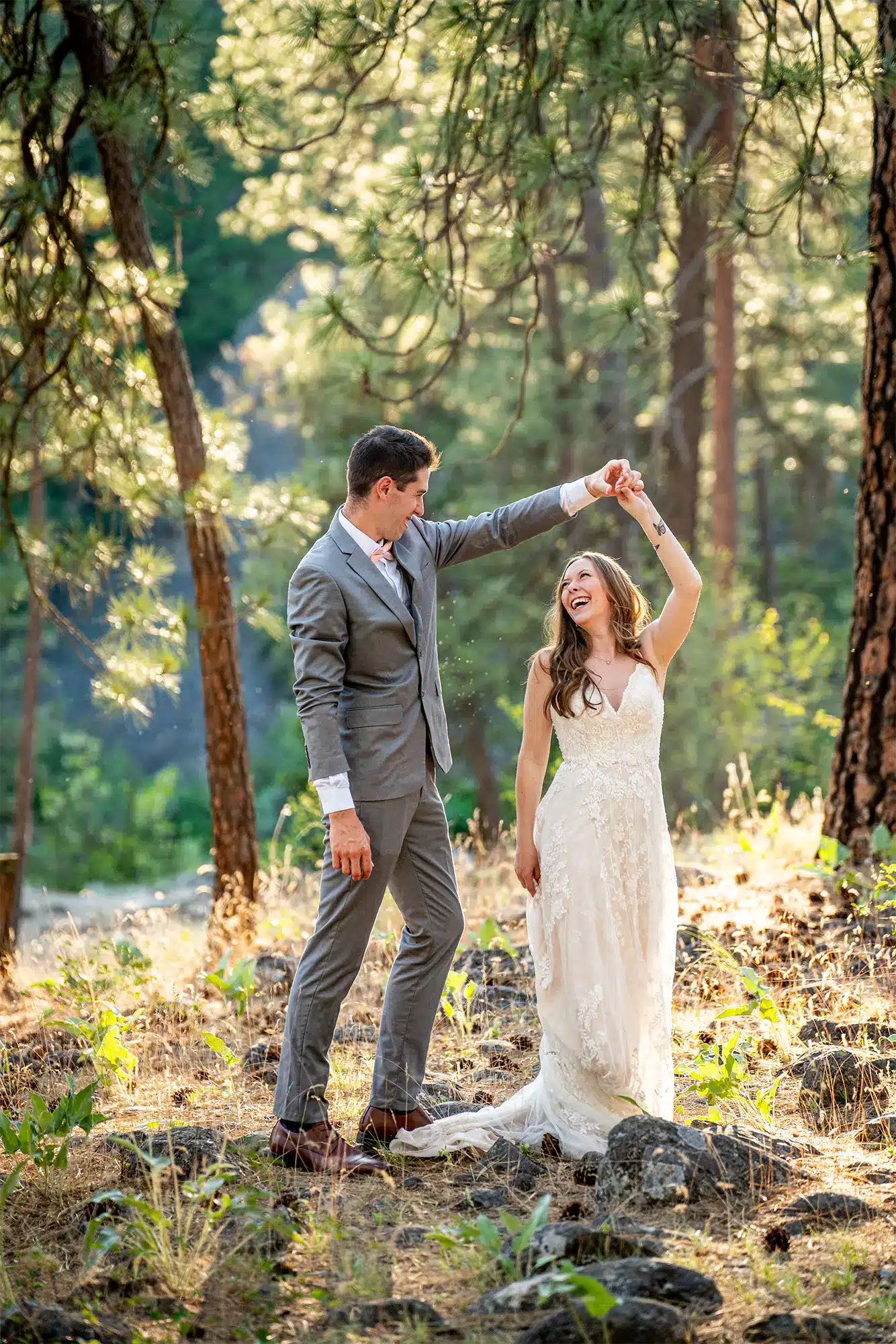 Groom twirls bride in sunlit forest setting. Groom twirls bride in sunlit forest setting.