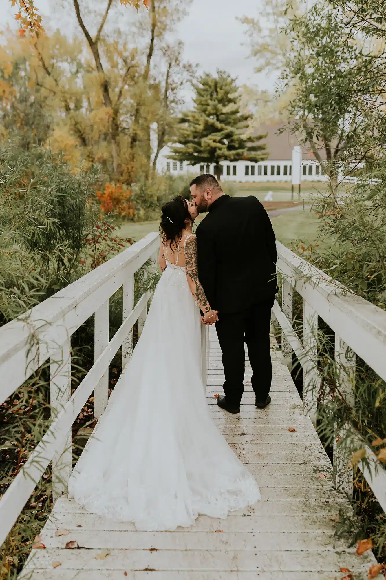 Bride and groom kiss on walk bridge at Barkhausen Waterfowl Preserve. Bride and groom kiss on walk bridge at Barkhausen Waterfowl Preserve.