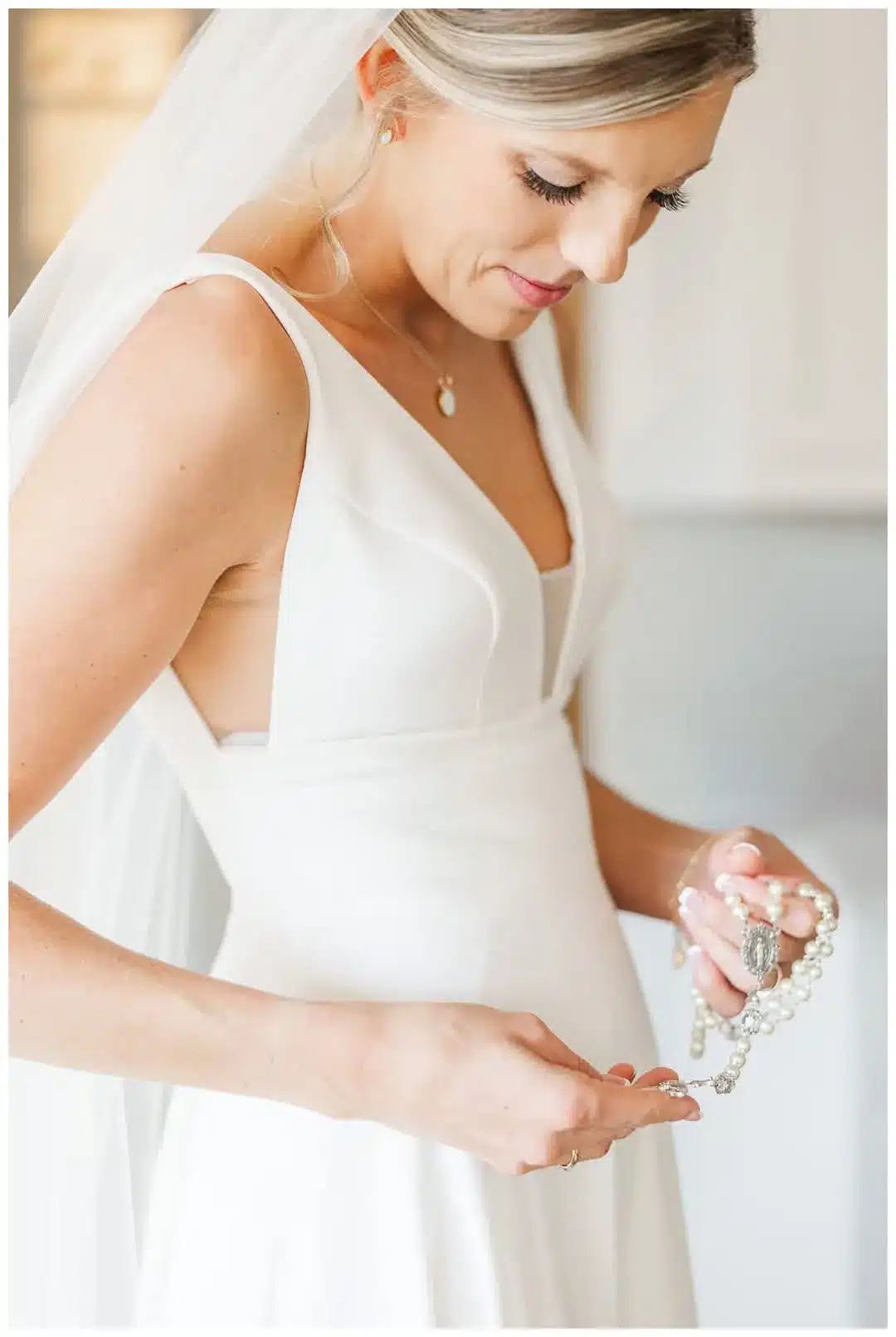 Bride looks down at her necklace.
