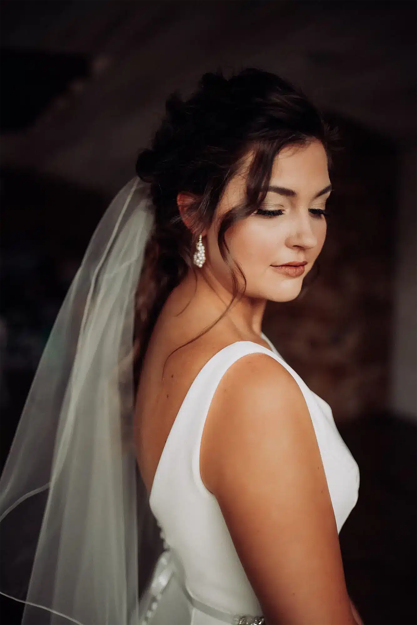 Bride in veil poses for a portrait.