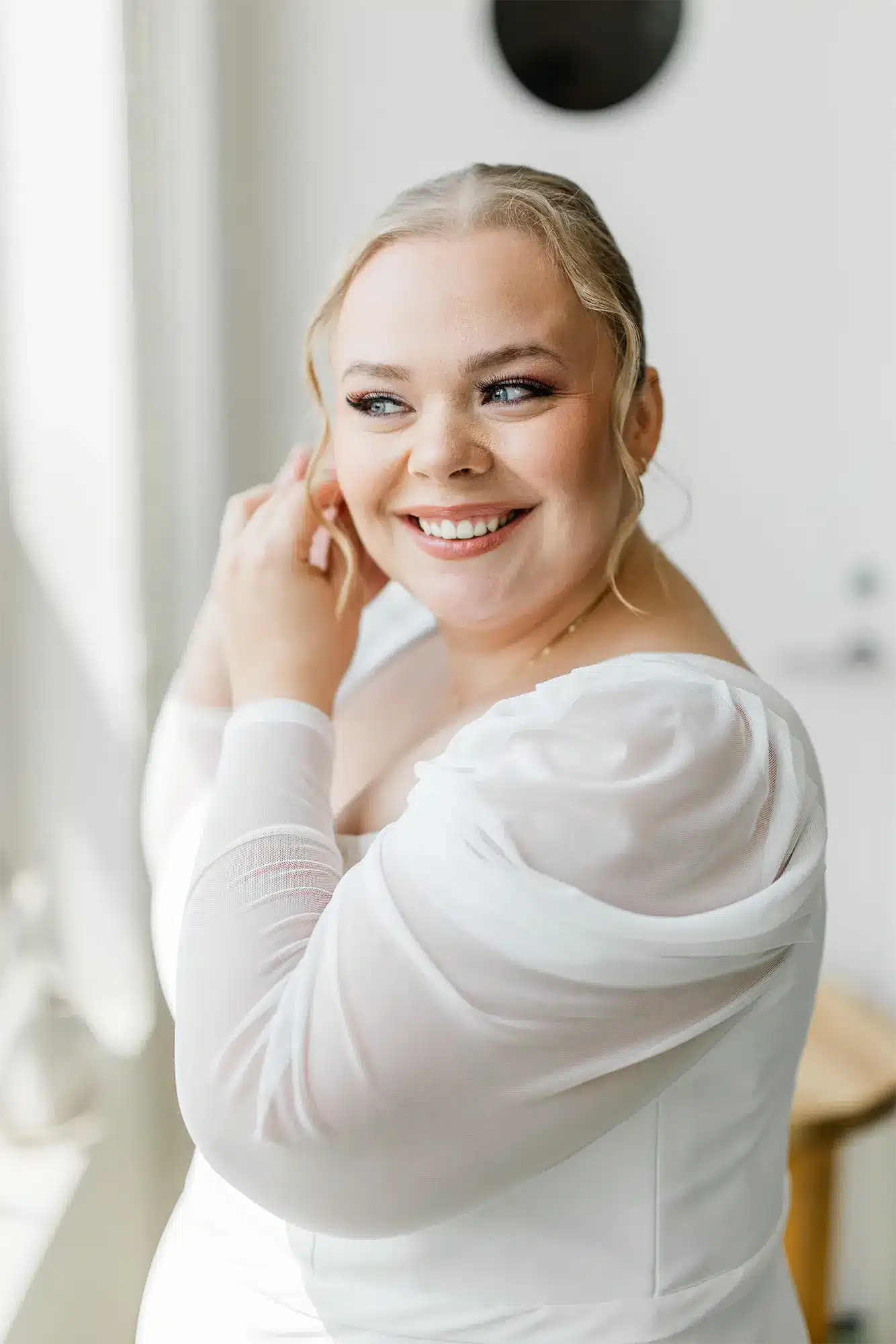 Bride Getting Ready Portrait at Kress Pavilion Smiling bride wearing a wedding gown fastening an earring.