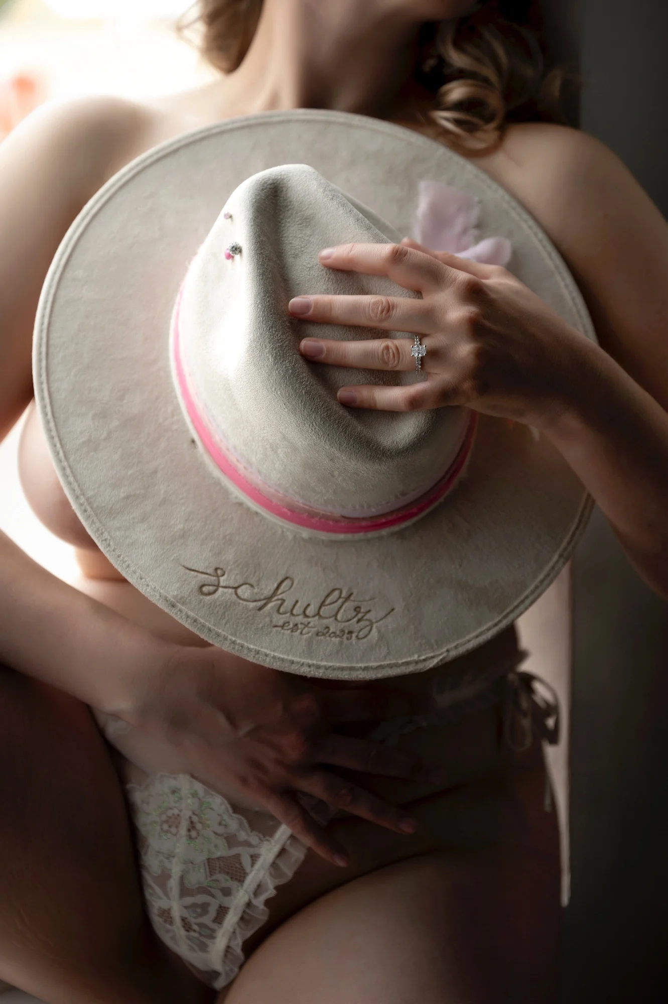 Close-up of lace lingerie and white hat with personalized bridal details.